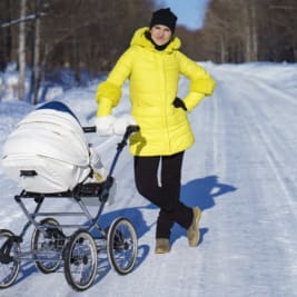 Woman on snowy road with baby stroller