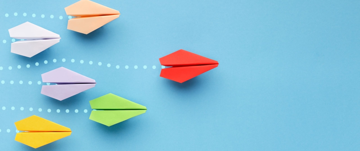 Opinion leadership concept. Red paper plane leading another colorful ones, influencing the crowd, blue background, panorama